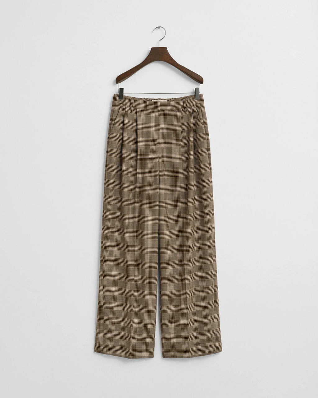 Plaid pants on a hanger against a white background