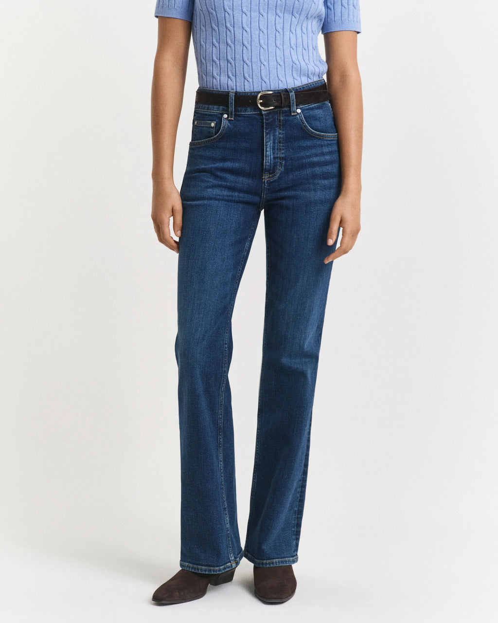 Person wearing blue jeans and a light blue shirt on a white background