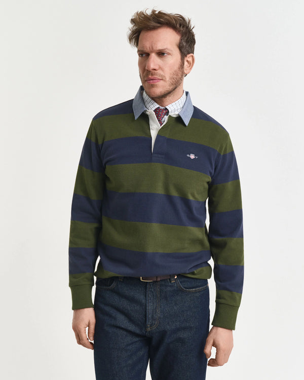 Man wearing a green and navy striped sweater with a white shirt underneath on a light gray background
