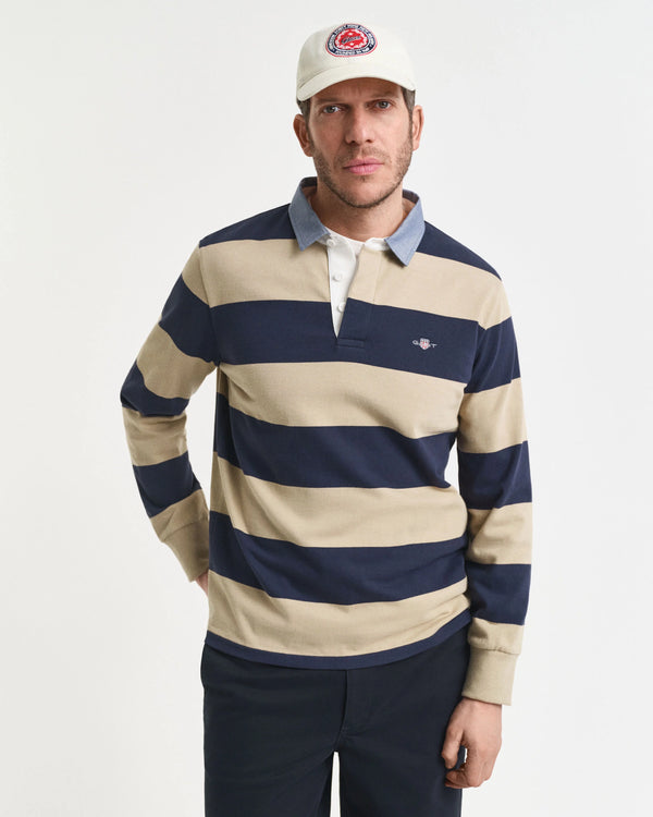 Man wearing a striped rugby shirt and cap on a white background