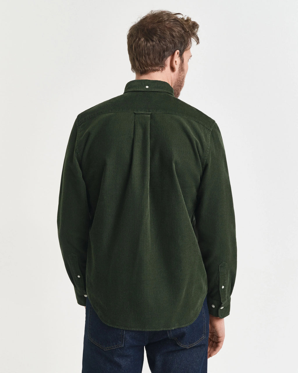 Man wearing a green shirt from behind on a white background