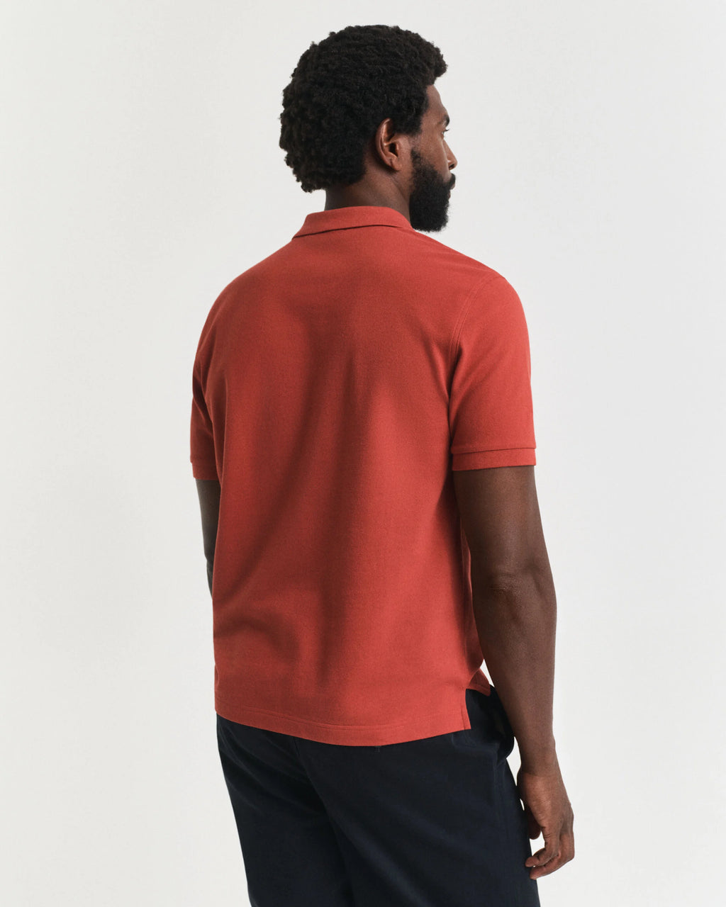 Man wearing a red polo shirt on a white background