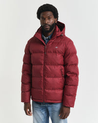 Man wearing a red puffer jacket on a white background