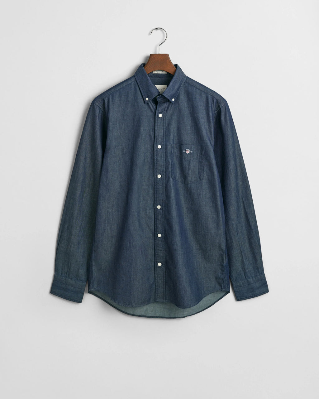 Blue button-up shirt on a hanger against a light gray background