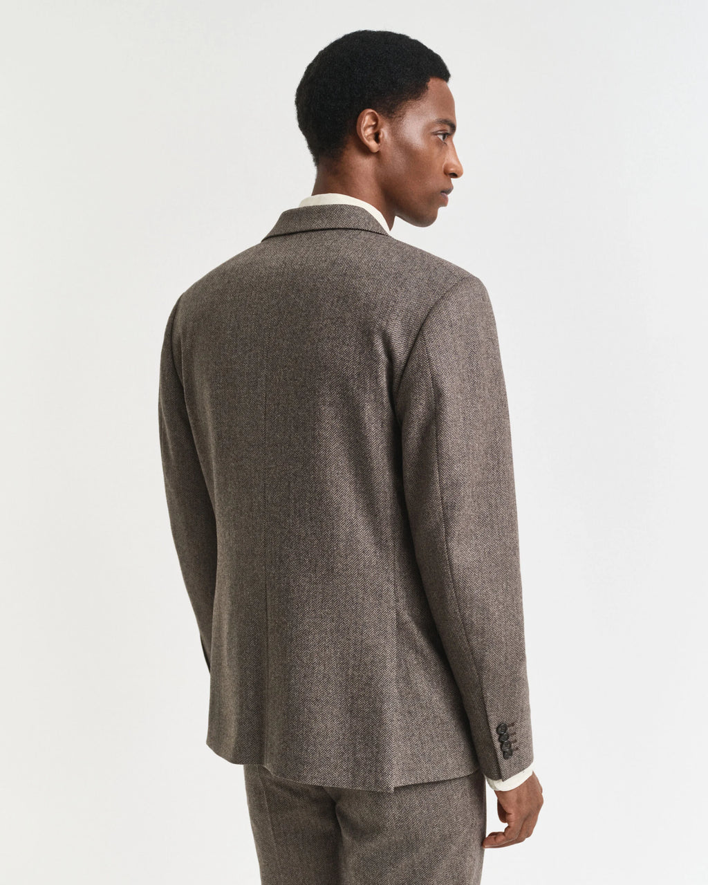 Man wearing a brown suit jacket on a white background