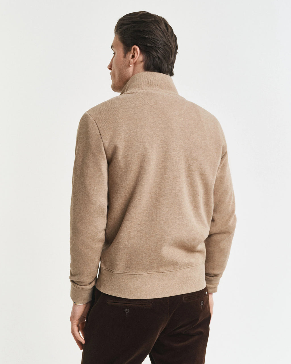 Man wearing a beige sweater on a white background