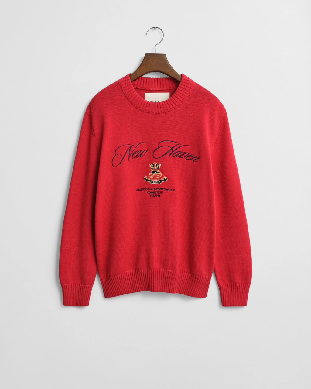 A red knitted sweater with a logo and text on a white background