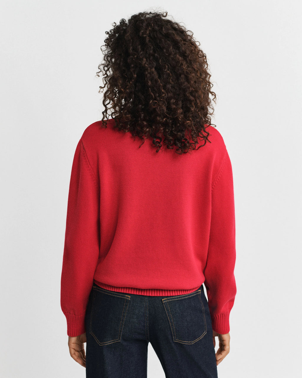 A woman wearing a red knitted sweater on a white background